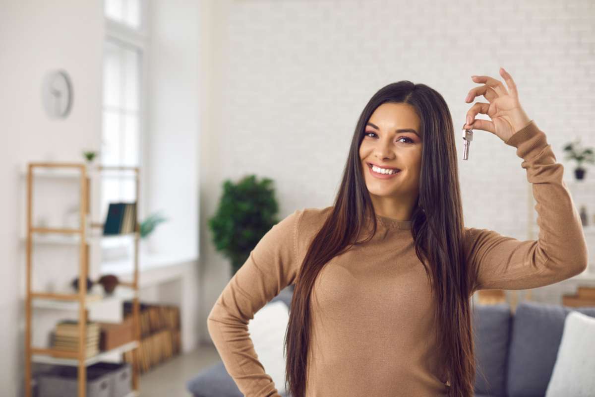 Happy woman holding keys to new home
