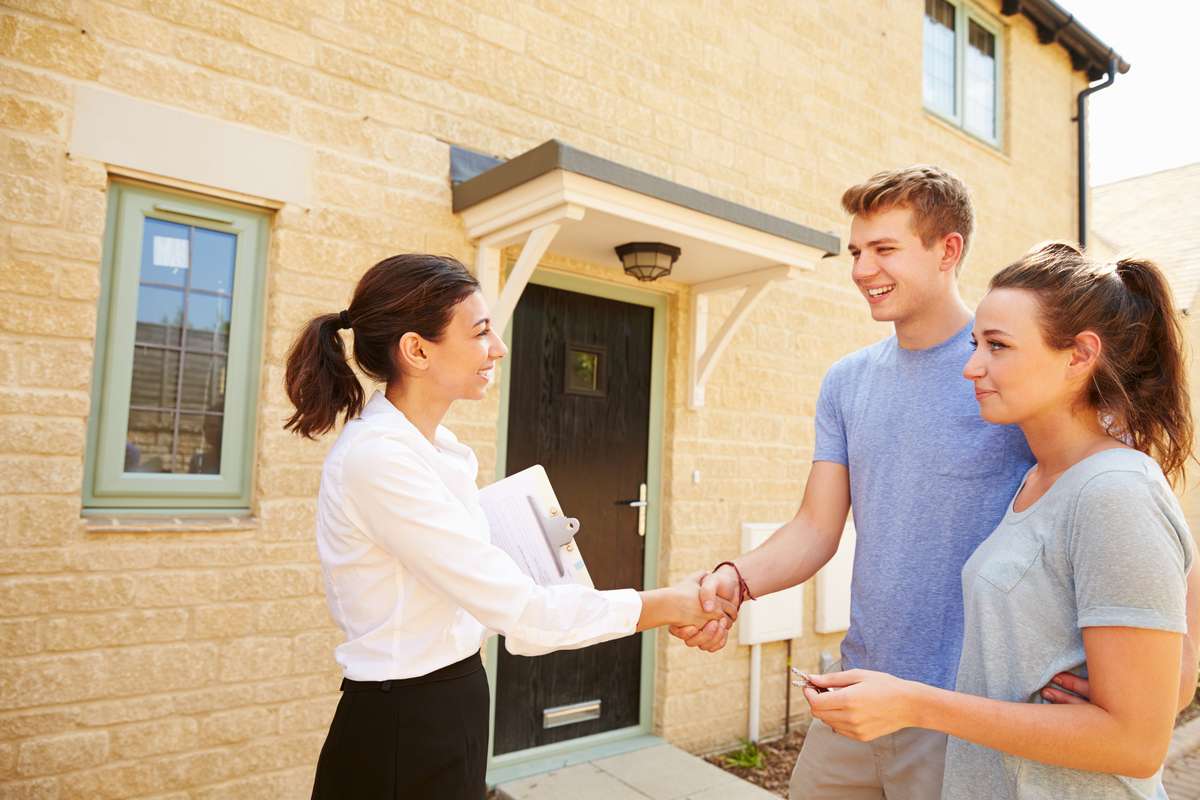Real estate agent shaking hands with owners (R) (S)